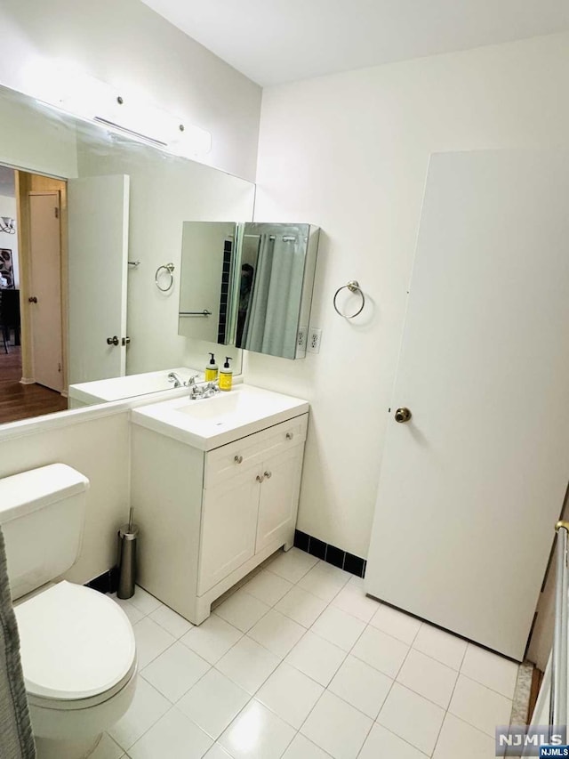 bathroom featuring tile patterned flooring, vanity, and toilet