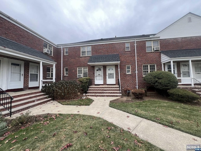 townhome / multi-family property featuring cooling unit and a front lawn