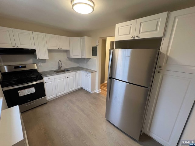 kitchen featuring sink, white cabinetry, stainless steel appliances, and light hardwood / wood-style flooring