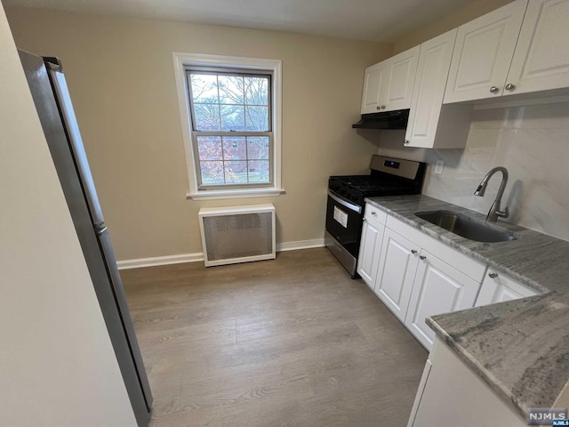 kitchen featuring white cabinets, stainless steel gas stove, sink, and hardwood / wood-style floors