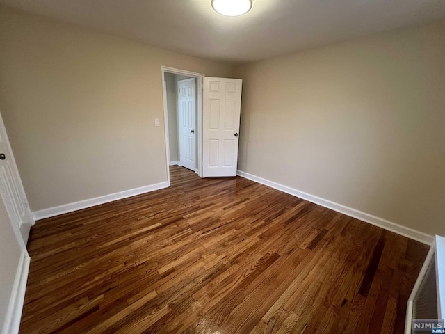 empty room with dark hardwood / wood-style floors