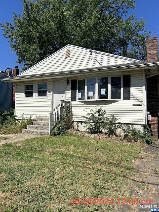 single story home featuring a front lawn