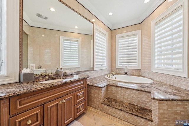 bathroom with tile patterned flooring, vanity, a relaxing tiled tub, and crown molding