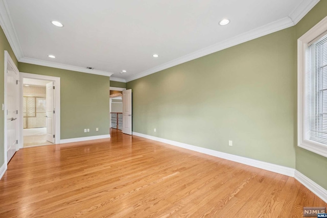 interior space with light wood-type flooring, connected bathroom, multiple windows, and crown molding