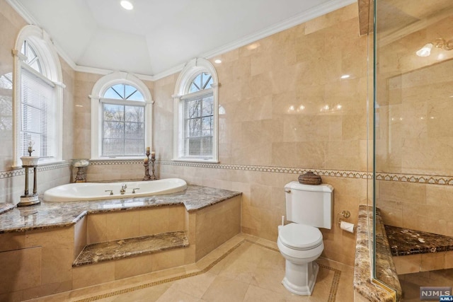 bathroom with tile patterned floors, shower with separate bathtub, toilet, tile walls, and ornamental molding