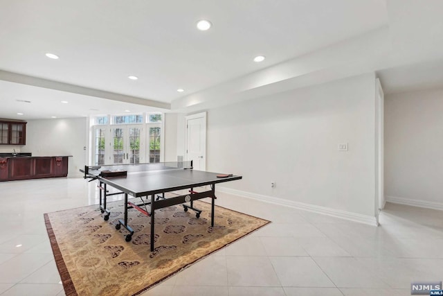 recreation room featuring bar area and light tile patterned floors