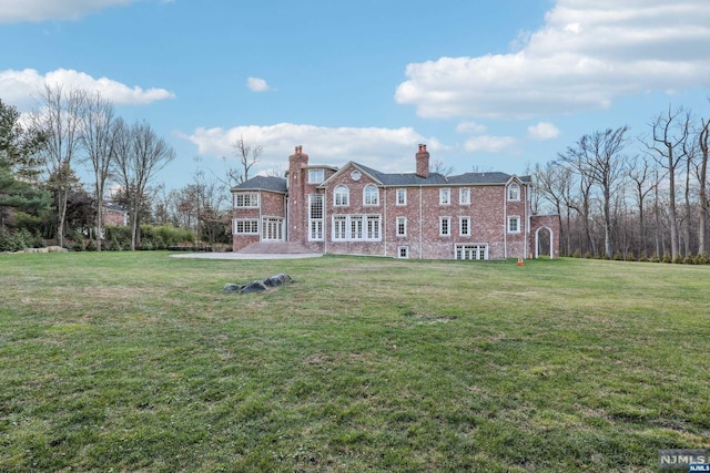 back of property with a yard and a patio