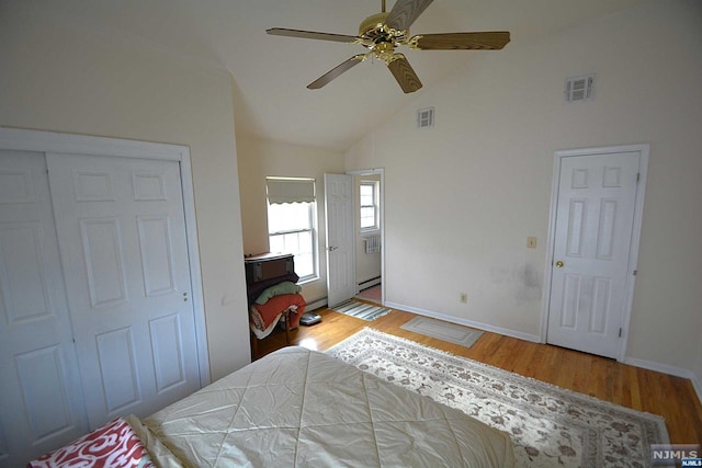 bedroom featuring ceiling fan, a closet, high vaulted ceiling, and light hardwood / wood-style flooring