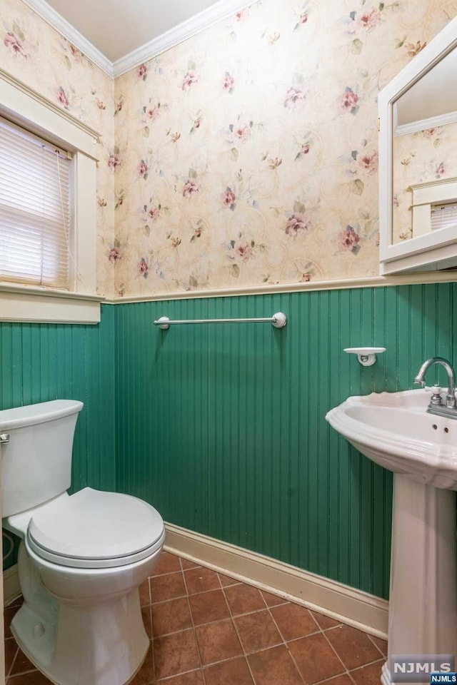 bathroom with tile patterned flooring, sink, toilet, and crown molding