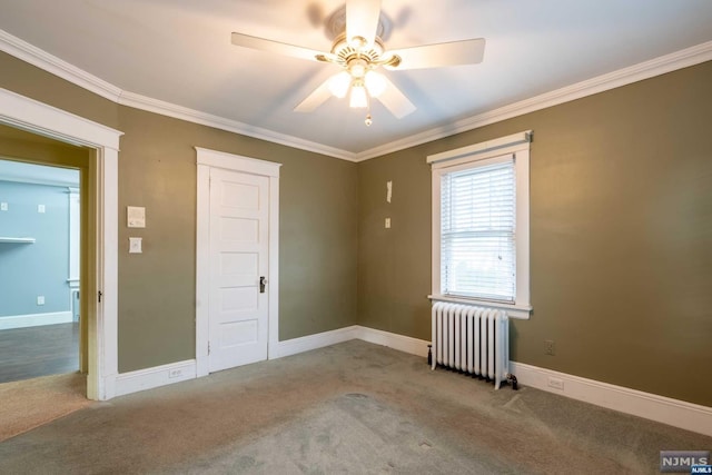 carpeted spare room with radiator heating unit, ceiling fan, and crown molding