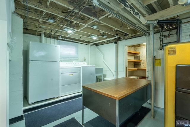 basement featuring washer and dryer, white fridge, and water heater