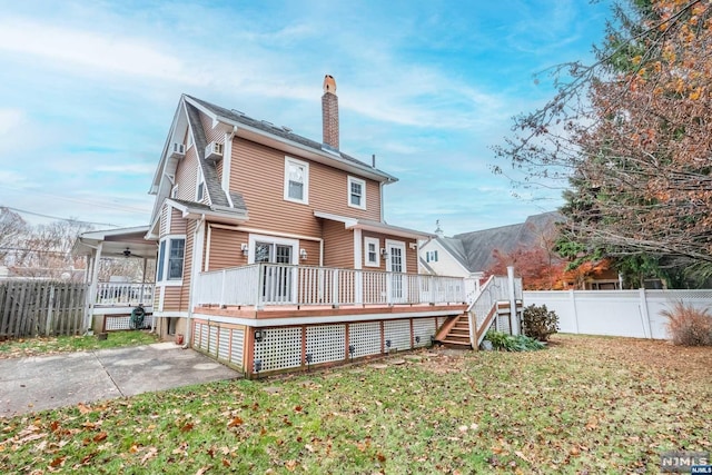 back of house featuring a patio, ceiling fan, a lawn, and a wooden deck