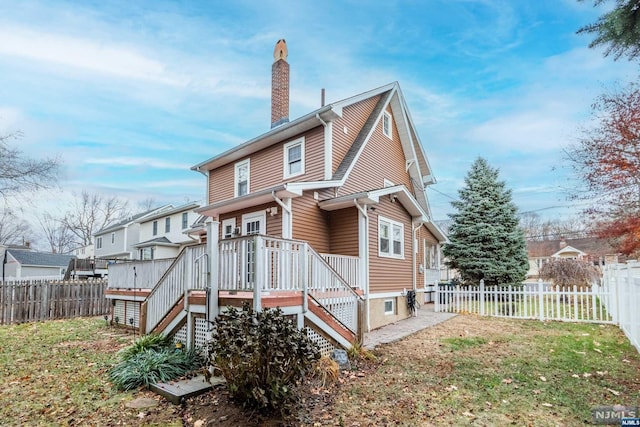 rear view of property with a lawn and a wooden deck