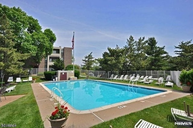 view of pool featuring a lawn