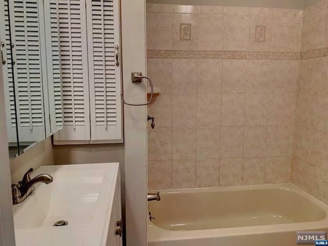 bathroom featuring vanity and tiled shower / bath combo