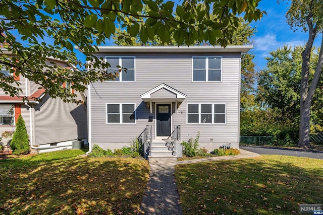 view of front of house featuring a front yard and central AC unit