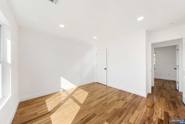 empty room with hardwood / wood-style flooring