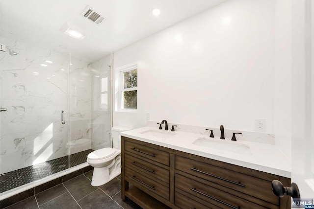 bathroom featuring tile patterned floors, vanity, toilet, and a shower with door