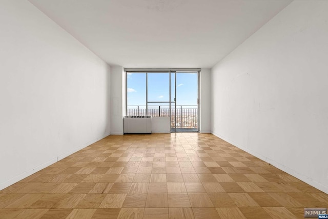 unfurnished room featuring radiator and expansive windows