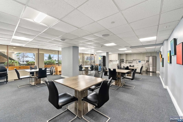 dining room featuring carpet flooring and a drop ceiling