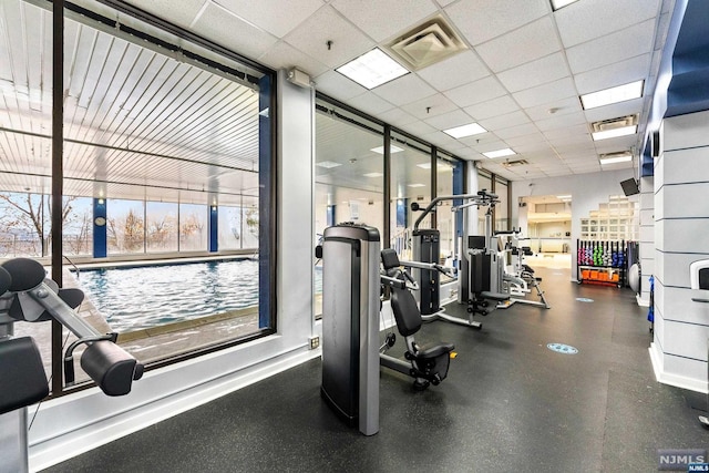 gym with a paneled ceiling