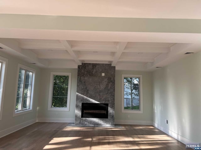 unfurnished living room with beam ceiling, a premium fireplace, dark wood-type flooring, and coffered ceiling