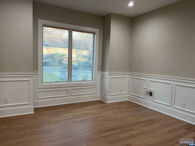 spare room with plenty of natural light and dark wood-type flooring