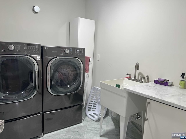 clothes washing area with light tile patterned floors and washer and clothes dryer