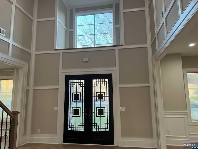 foyer with french doors and a towering ceiling