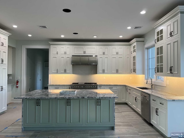 kitchen with a center island, light stone counters, stainless steel dishwasher, and black range with gas cooktop