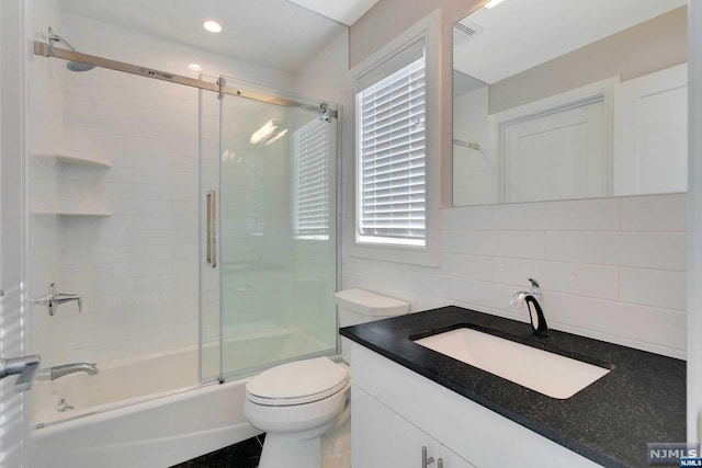 full bathroom featuring vanity, tasteful backsplash, toilet, and enclosed tub / shower combo