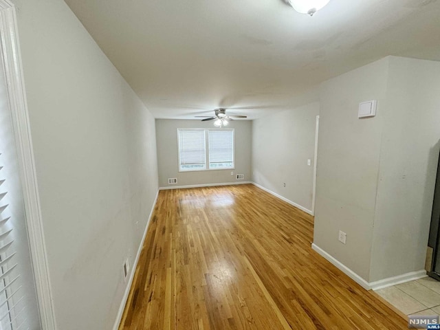 unfurnished room with ceiling fan and light wood-type flooring