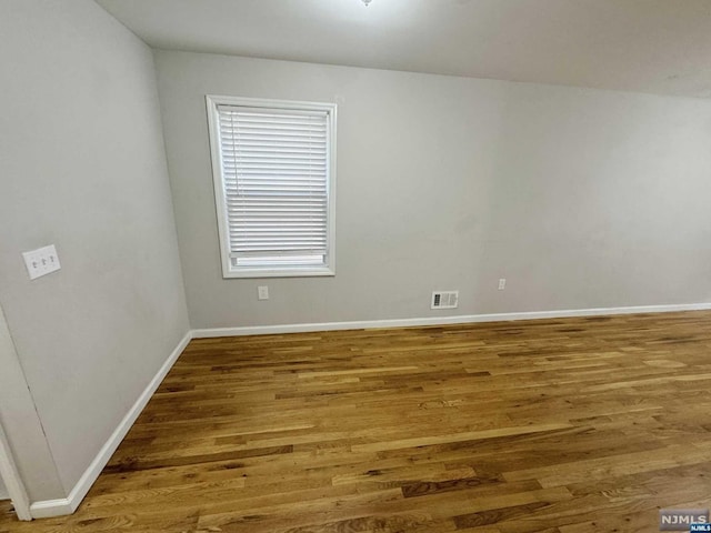 empty room with hardwood / wood-style floors