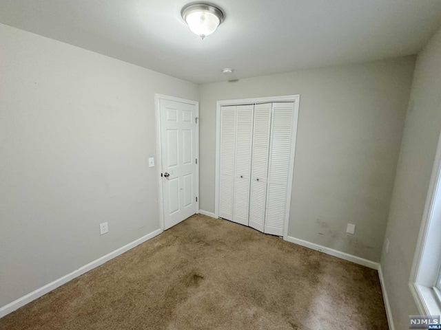 unfurnished bedroom with carpet and a closet