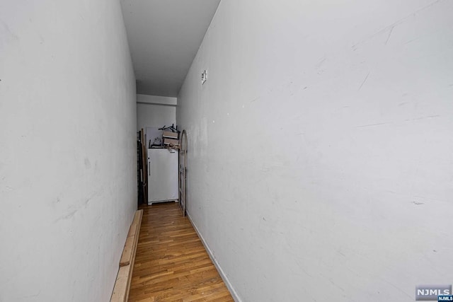 hallway with hardwood / wood-style flooring