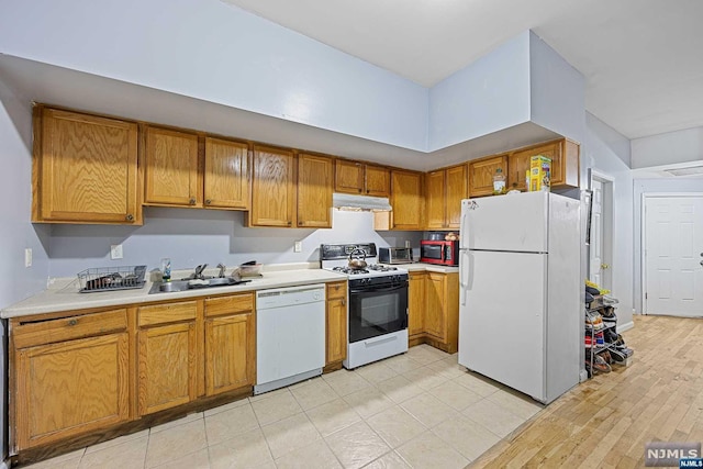 kitchen featuring sink, white appliances, and light wood-type flooring