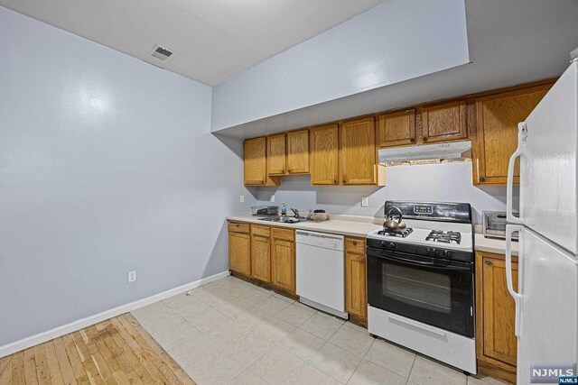 kitchen featuring sink, white appliances, and light hardwood / wood-style flooring