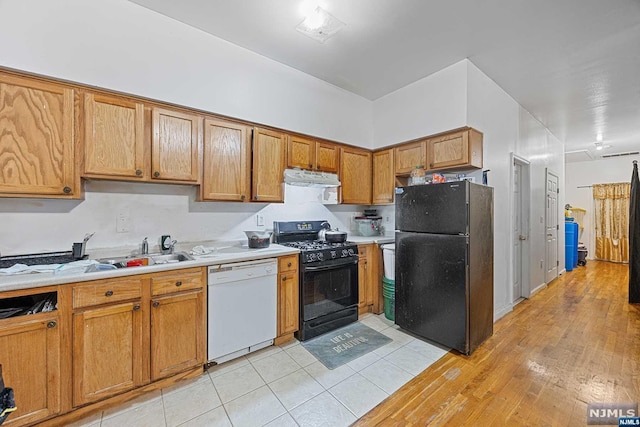 kitchen with sink, light hardwood / wood-style floors, and black appliances