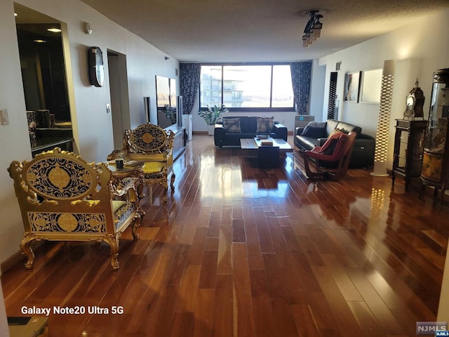 living room with dark wood-type flooring and baseboards