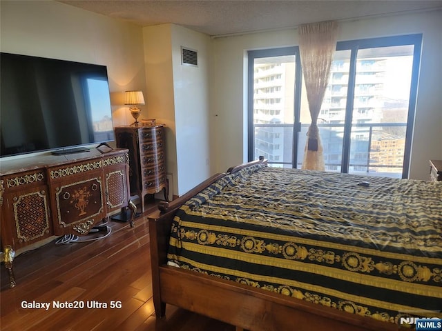 bedroom with visible vents and wood finished floors