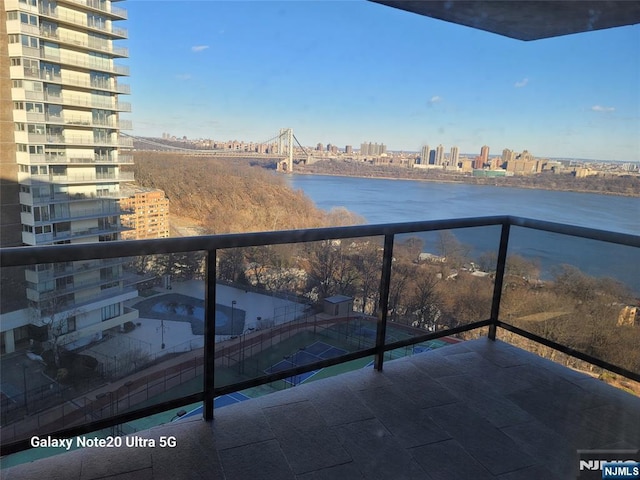 balcony featuring a water view and a city view