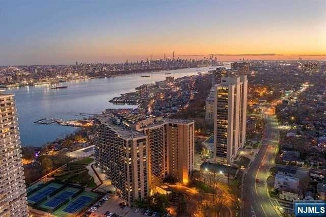 aerial view at dusk with a water view and a view of city