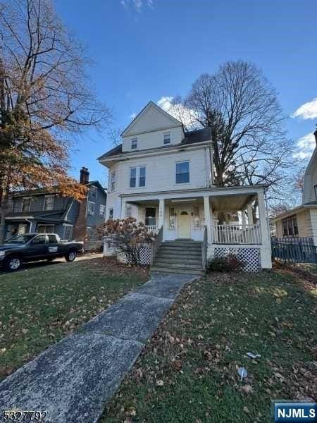 view of front of property featuring covered porch and a front yard