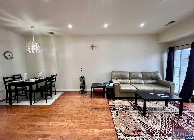 living room with wood-type flooring and an inviting chandelier