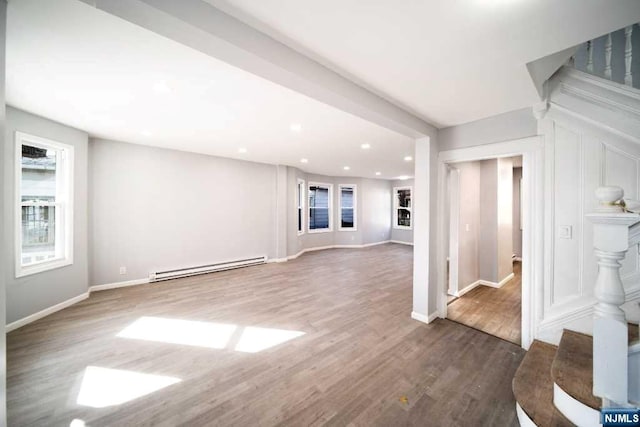 unfurnished living room featuring dark hardwood / wood-style floors and baseboard heating