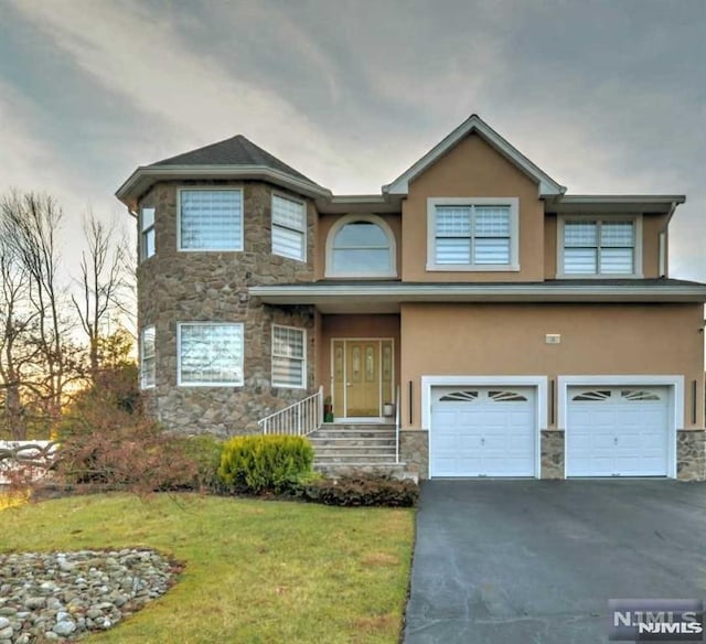 view of front of property with a garage and a lawn