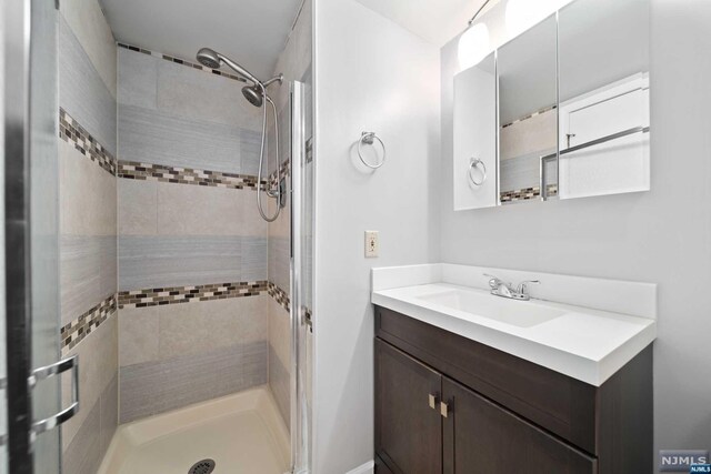 bathroom featuring vanity and a tile shower