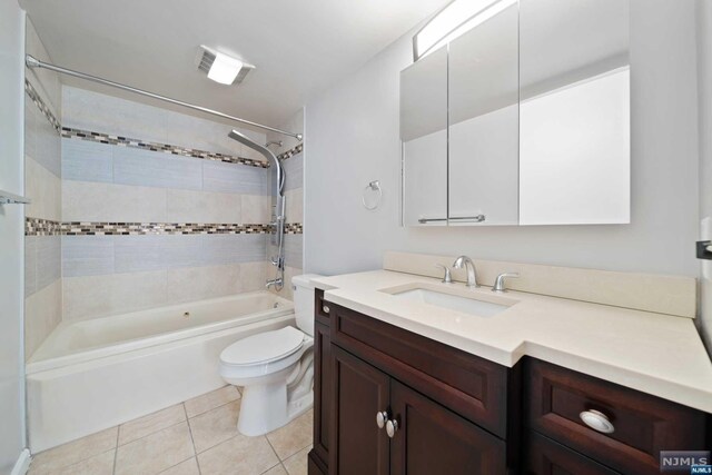 full bathroom with tile patterned floors, vanity, toilet, and tiled shower / bath