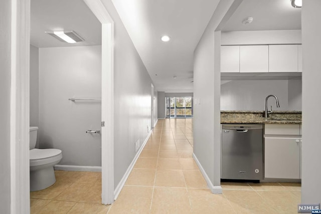 hall featuring light tile patterned floors and sink