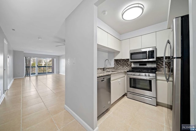 kitchen with white cabinets, sink, appliances with stainless steel finishes, tasteful backsplash, and light tile patterned flooring